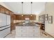 Gourmet kitchen featuring a large island with granite countertops and custom wood cabinetry at 673 Brentwood St, Lakewood, CO 80214
