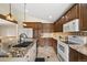 Kitchen featuring granite countertops, wooden cabinets, and modern appliances at 673 Brentwood St, Lakewood, CO 80214