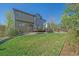 Green backyard with a patio, large windows, and mature trees provides a peaceful outdoor space at 10127 W 100Th Ct, Westminster, CO 80021