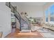 Bright entryway featuring a staircase with black railings, hardwood floors, and large windows, creating an inviting space at 10127 W 100Th Ct, Westminster, CO 80021