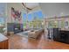 Bright, spacious living room featuring a fireplace, large windows, and hardwood floors, seamlessly connecting to the kitchen at 10127 W 100Th Ct, Westminster, CO 80021