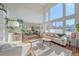 Sunlit living room with high ceilings, large windows, hardwood floors, and a modern sofa, perfect for relaxation at 10127 W 100Th Ct, Westminster, CO 80021
