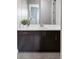 Elegant bathroom vanity with dark wood cabinets, white countertop, sink, and mirror at 9388 E 59Th Pl, Denver, CO 80238