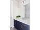 Clean bathroom featuring a white countertop, dark vanity, and a large mirror at 9388 E 59Th Pl, Denver, CO 80238