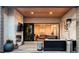 Enjoy the cozy ambiance of the covered patio with a fireplace, TV, and access to the outdoor seating area at 9388 E 59Th Pl, Denver, CO 80238