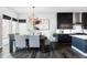 Dining area with modern lighting, dark wood floors, and views of the kitchen and outdoor area at 9388 E 59Th Pl, Denver, CO 80238
