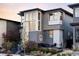 Beautiful two-story home with eye-catching architectural features, gray siding, and lovely landscaping at 9388 E 59Th Pl, Denver, CO 80238