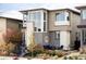 Modern home with gray siding, stone accents, large windows, and a cozy front patio at 9388 E 59Th Pl, Denver, CO 80238