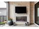 Outdoor fireplace with stone surround, TV, and cozy ambiance for relaxing evenings at 9388 E 59Th Pl, Denver, CO 80238