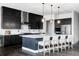 A gourmet kitchen with dark cabinetry, a large island, stainless steel appliances, and designer pendant lighting at 9388 E 59Th Pl, Denver, CO 80238
