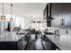 Open concept kitchen with dark cabinets, stainless steel appliances, large island, and dining area at 9388 E 59Th Pl, Denver, CO 80238