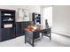Well-lit home office featuring a wood desk, black bookcases, and a decorative painting at 9388 E 59Th Pl, Denver, CO 80238