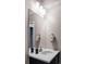 Compact powder room with dark vanity, white countertop, contemporary fixtures, and decorative accents at 9388 E 59Th Pl, Denver, CO 80238