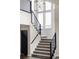 Modern staircase with carpeted steps, sleek black railing, and abundant natural light at 9388 E 59Th Pl, Denver, CO 80238