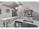 Finished basement bar with brick accents, white countertop, beverage fridge, and decorative signs for entertaining at 1588 W 111Th Ave, Northglenn, CO 80234