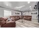Spacious basement with a large leather sectional sofa, neutral gray walls, and modern flooring at 1588 W 111Th Ave, Northglenn, CO 80234