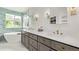 Elegant bathroom featuring double sinks with a white countertop, custom cabinets, and a sleek, standalone bathtub at 1588 W 111Th Ave, Northglenn, CO 80234