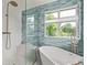 Spa-like bathroom showcasing a modern tub, stylish tilework, brass fixtures, and a separate glass-enclosed shower at 1588 W 111Th Ave, Northglenn, CO 80234