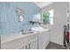 Bright laundry room with blue tiled wall, modern washer and dryer, and ample storage space for convenience at 1588 W 111Th Ave, Northglenn, CO 80234