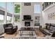 Comfortable living room featuring stone fireplace, large windows, and a leather sofa set at 1588 W 111Th Ave, Northglenn, CO 80234
