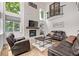Cozy living room with stone fireplace, hardwood floors, and large windows showcasing greenery at 1588 W 111Th Ave, Northglenn, CO 80234