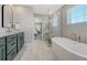 Bright bathroom featuring a soaking tub, glass shower and dual-sink vanity at 2541 Leafdale Cir, Castle Rock, CO 80109