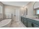 Bathroom featuring undermount sinks, modern cabinets, freestanding tub, and large mirror at 2541 Leafdale Cir, Castle Rock, CO 80109