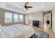 Bedroom featuring tray ceiling, ceiling fan, hardwood floors, three windows, and ensuite bathroom at 2541 Leafdale Cir, Castle Rock, CO 80109