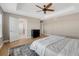 Spacious bedroom featuring tray ceiling, ceiling fan, hardwood floors, and an ensuite bathroom at 2541 Leafdale Cir, Castle Rock, CO 80109