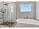 Bright bathroom featuring a soaking tub and tiled glass shower with rainfall shower head at 2541 Leafdale Cir, Castle Rock, CO 80109