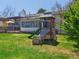 Landscaped backyard featuring a play structure and a multi-level deck at 9045 E Floyd Ave, Denver, CO 80231