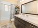 Bathroom featuring a vanity with ample counter space, stylish mirror, and a shower/tub combination at 9045 E Floyd Ave, Denver, CO 80231