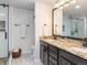 Modern bathroom with dual sinks, granite countertops, a glass-enclosed shower, and updated fixtures at 9045 E Floyd Ave, Denver, CO 80231