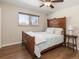 Cozy bedroom featuring a wood-framed bed, hardwood floors, a ceiling fan, and a window view at 9045 E Floyd Ave, Denver, CO 80231