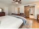 Bright bedroom featuring hardwood floors, a ceiling fan, and a modern sliding barn door to the bathroom at 9045 E Floyd Ave, Denver, CO 80231