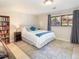 Comfortable bedroom with a queen bed, large window, and decorative throw pillows at 9045 E Floyd Ave, Denver, CO 80231
