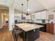 Contemporary kitchen featuring stainless steel appliances, a large island, and stylish pendant lighting at 9045 E Floyd Ave, Denver, CO 80231