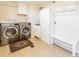 Well-equipped laundry room with washer, dryer, storage cabinets, and utility sink at 9045 E Floyd Ave, Denver, CO 80231