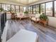 Bright sunroom filled with natural light features stylish furniture and wood-look flooring at 9045 E Floyd Ave, Denver, CO 80231