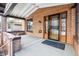 Covered front porch with brick columns and a wood front door at 1149 Steele St, Denver, CO 80206