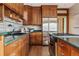 Spacious kitchen with dark wood cabinets, granite countertops, and stainless steel appliances at 1149 Steele St, Denver, CO 80206