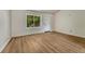 Bright bedroom featuring wood-look floors, white walls, and a window with pleasant outdoor view at 5380 S Prescott St, Littleton, CO 80120