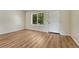 Bright bedroom featuring wood-look floors, white walls, and a window and door providing plenty of natural light at 5380 S Prescott St, Littleton, CO 80120