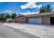 Brick home featuring an attached garage, driveway and mature trees surrounding the property at 5380 S Prescott St, Littleton, CO 80120