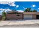 Exterior view of a brick home featuring an attached garage and mature trees surrounding the property at 5380 S Prescott St, Littleton, CO 80120