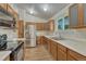 Well-lit kitchen with stainless steel appliances, double sink, and wood cabinets at 5380 S Prescott St, Littleton, CO 80120