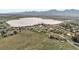 Scenic aerial view of a neighborhood by a lake surrounded by fields and mountains in the background at 1069 Crestmoor Dr, Boulder, CO 80303