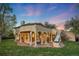 Beautiful covered back patio with stone flooring, columns, and an outdoor fire pit on a well maintained lawn at 1069 Crestmoor Dr, Boulder, CO 80303