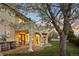 Covered back porch with chairs, barrel table, and stone floors; perfect for relaxing outdoors at twilight at 1069 Crestmoor Dr, Boulder, CO 80303