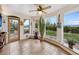 Bright sun room with tiled flooring, ceiling fan, large windows offering mountain views, and door to patio at 1069 Crestmoor Dr, Boulder, CO 80303